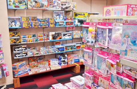 〈関連〉人形の近くに車のおもちゃが並ぶおもちゃ屋。売り場を性別で分けていない＝鹿児島市の丸新玩具中町本店