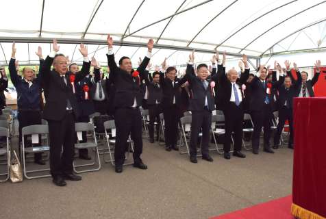 黒之瀬戸大橋開通５０年を祝い、万歳三唱する式典参加者ら＝９日、長島町の道の駅だんだん市場