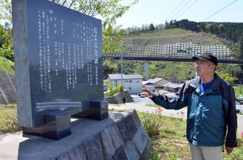 〈関連〉復興工事の記念碑前に立つ坂田哲也さん＝熊本県西原村の大切畑地区