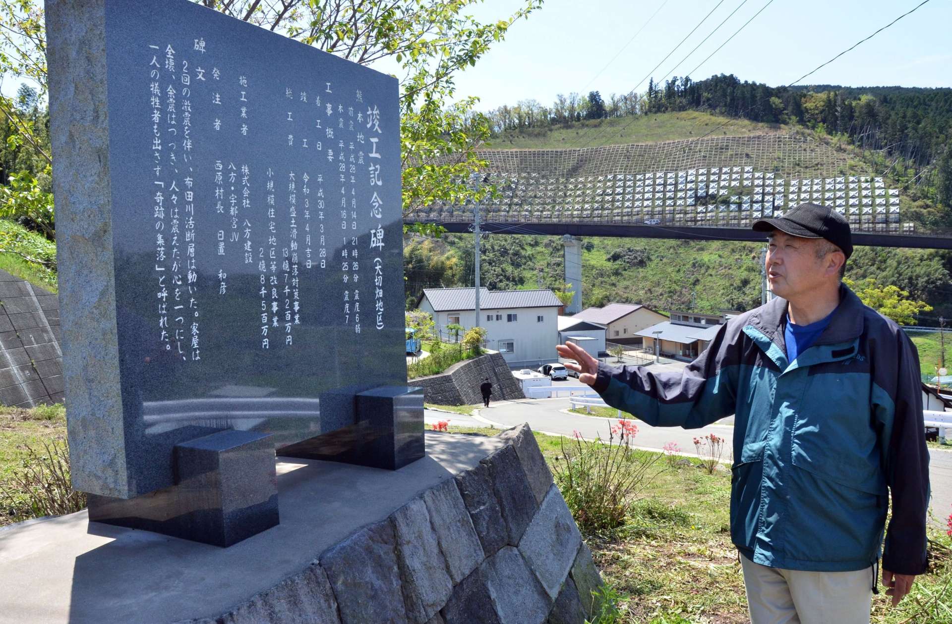 〈関連〉復興工事の記念碑前に立つ坂田哲也さん＝熊本県西原村の大切畑地区