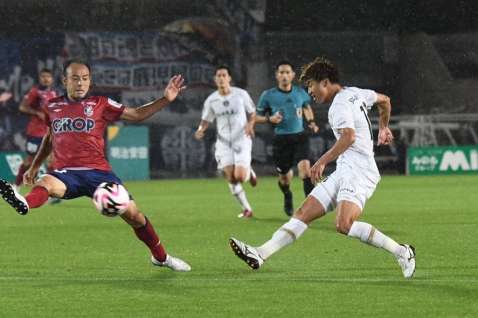 前半、ゴール前にパスを送る鹿児島ＵのＭＦ福田（右）＝シティライトスタジアム