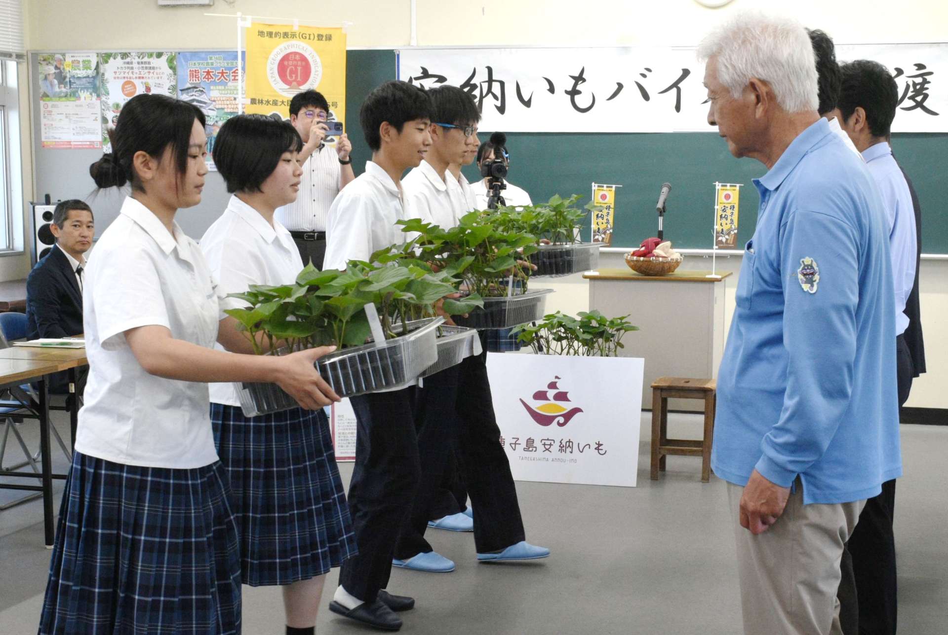 安納いもの生産者らにバイオ苗を手渡す種子島高校生物生産科の生徒たち＝１０日、西之表市の同校