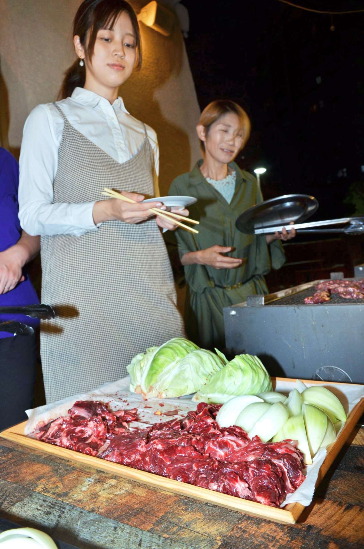 クジラ肉でバーベキューを楽しむ参加者＝９日、鹿児島市