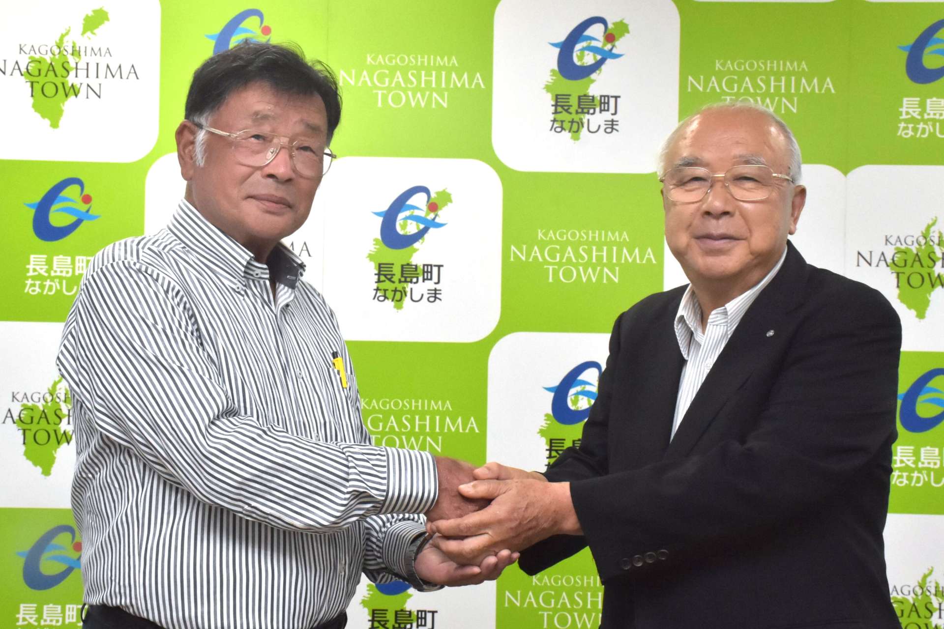 代替バス運行の委託契約を結んだ長島町の川添健町長（右）とＮＰＯの川添英一代表理事＝長島町役場