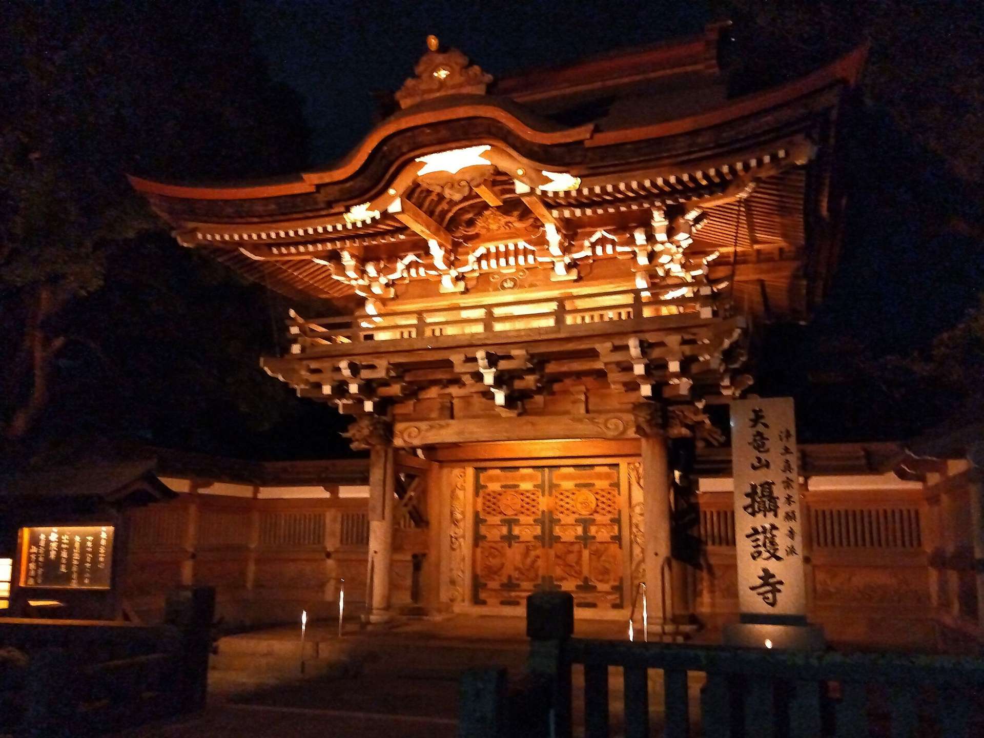 認知症のシンボルカラーであるオレンジ色でライトアップされた攝護寺の山門＝１９日、都城市牟田町