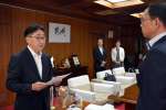 池田宜永市長（右）＝に評価結果を報告する宮内孝委員長＝２０日、都城市役所