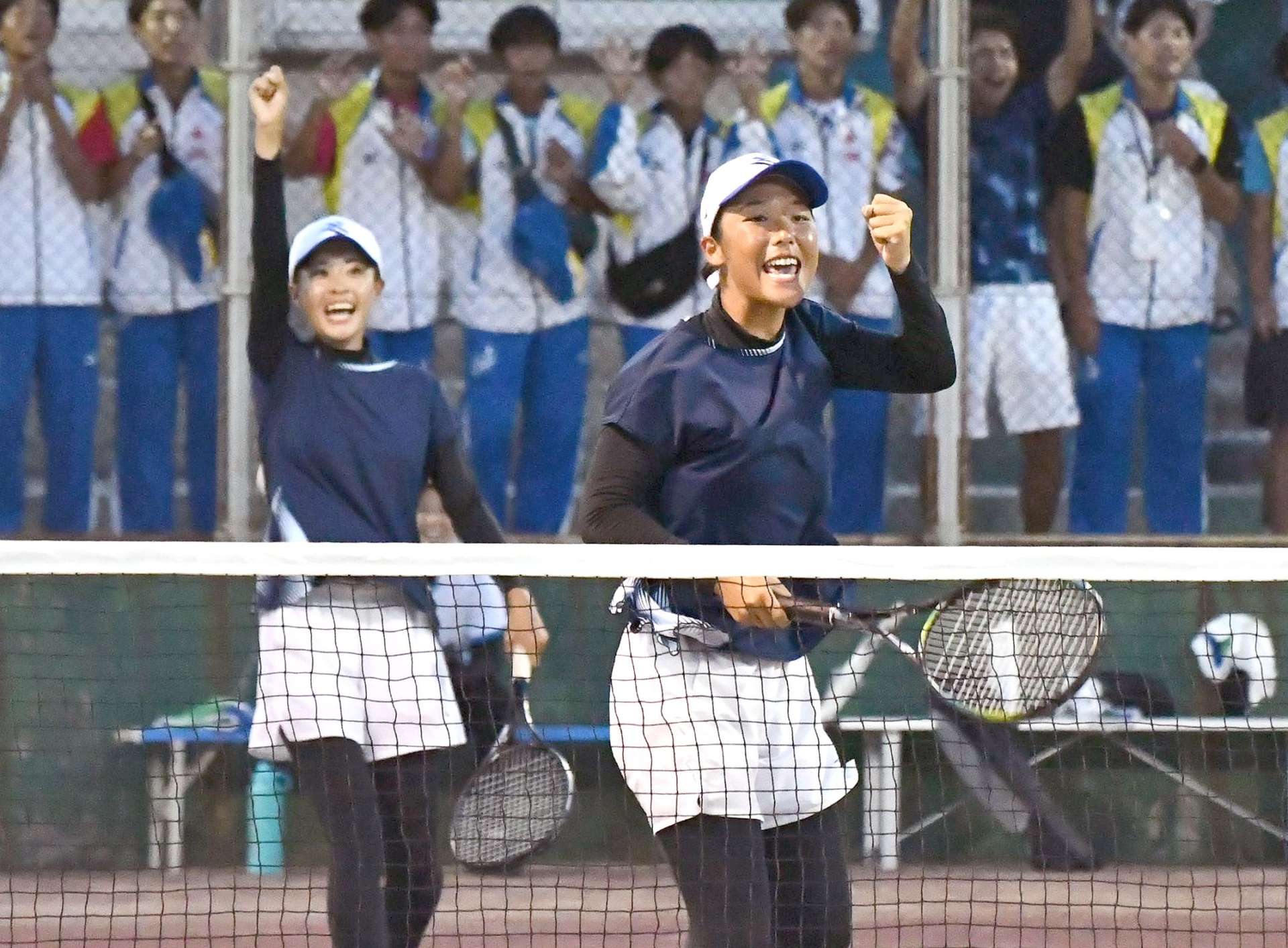 成年女子２回戦、得点を決め喜ぶ鹿児島の山本（手前）と末吉＝唐津市松浦河畔公園庭球場