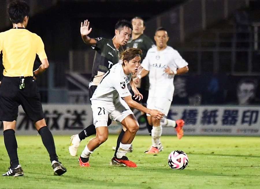 前半、中盤で競り合う鹿児島Ｕの田中（２１）＝栃木県グリーンスタジアム