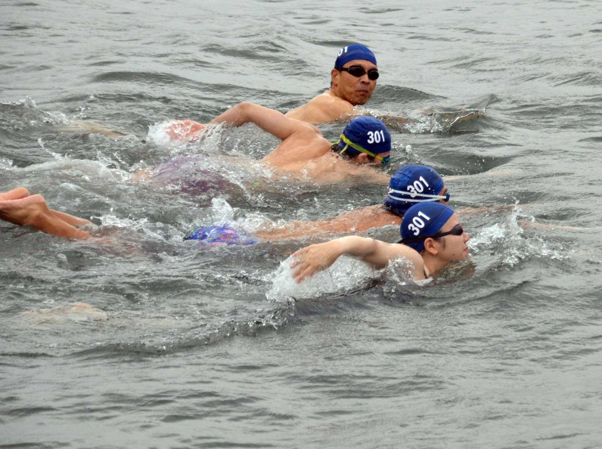 強い風が吹く中、横断に挑戦する選手＝２３日、鹿児島市桜島小池町の桜島小池海岸
