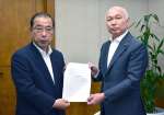 松里保広議長に決議案を手渡す県民連合の福司山宣介会長（右）＝２４日、県議会庁舎