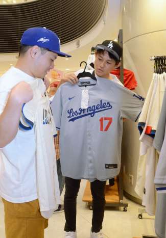 大谷翔平選手着用のものと同じデザインのユニホームを選ぶ客＝４日、鹿児島市のアミュプラザ鹿児島