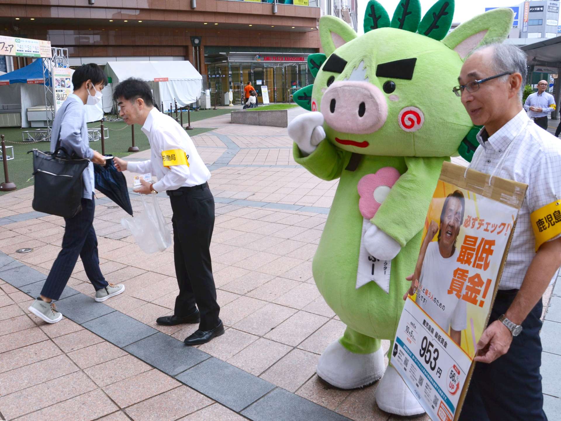 最低賃金の引き上げを知らせるポケットティッシュを手渡す鹿児島労働局の永野和則局長＝４日、鹿児島市のＪＲ鹿児島中央駅前