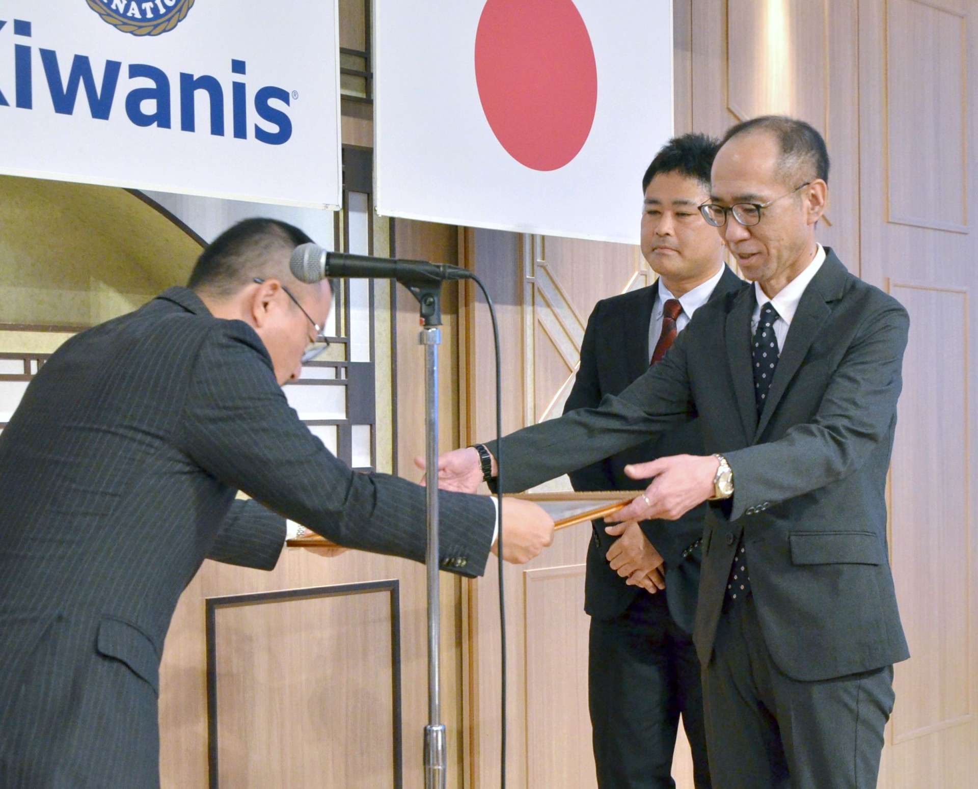 表彰状を受け取る「こども医療ネットワーク」の岡本康裕理事長（右）＝鹿児島市の城山ホテル鹿児島