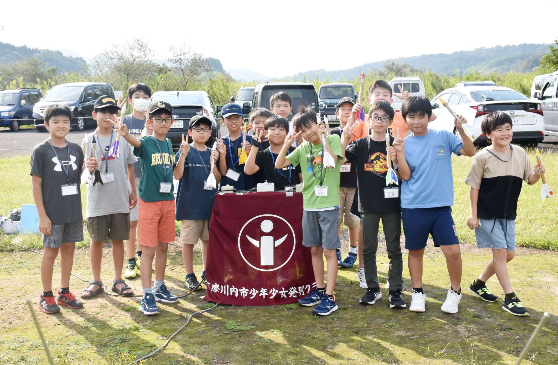 手作りのモデルロケットを手に笑顔を見せる小学生＝薩摩川内市の小倉運動広場