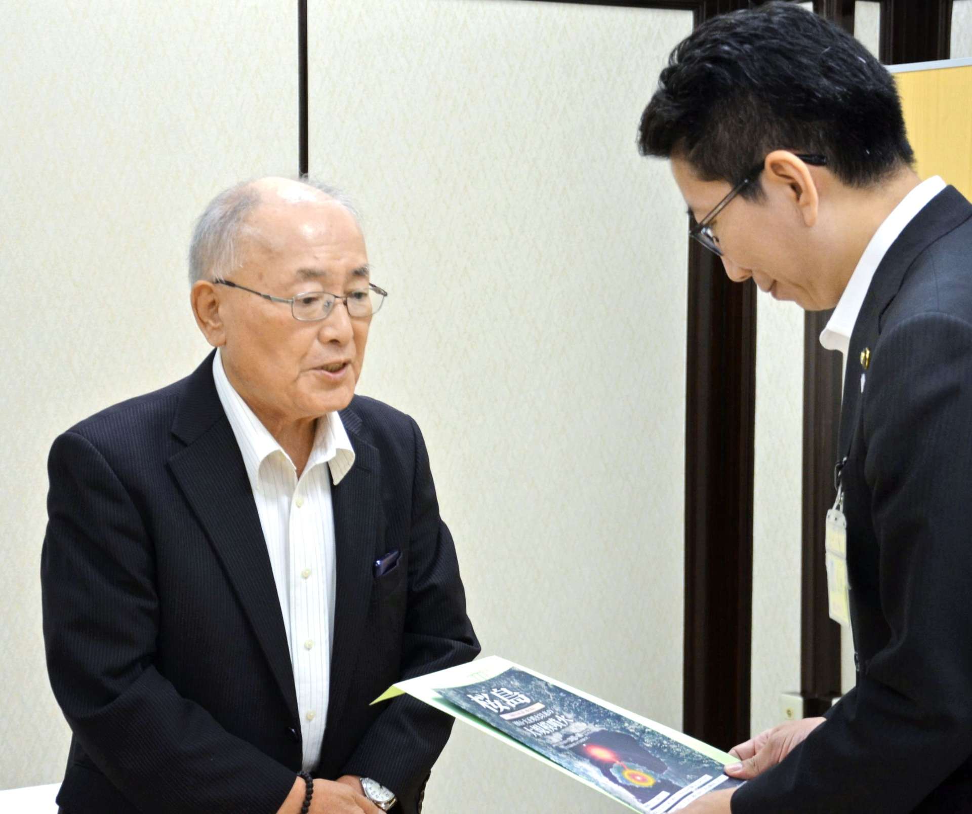 八幡校区コミュニティ協議会の取り組みを報告する和田一雄会長＝鹿児島市役所
