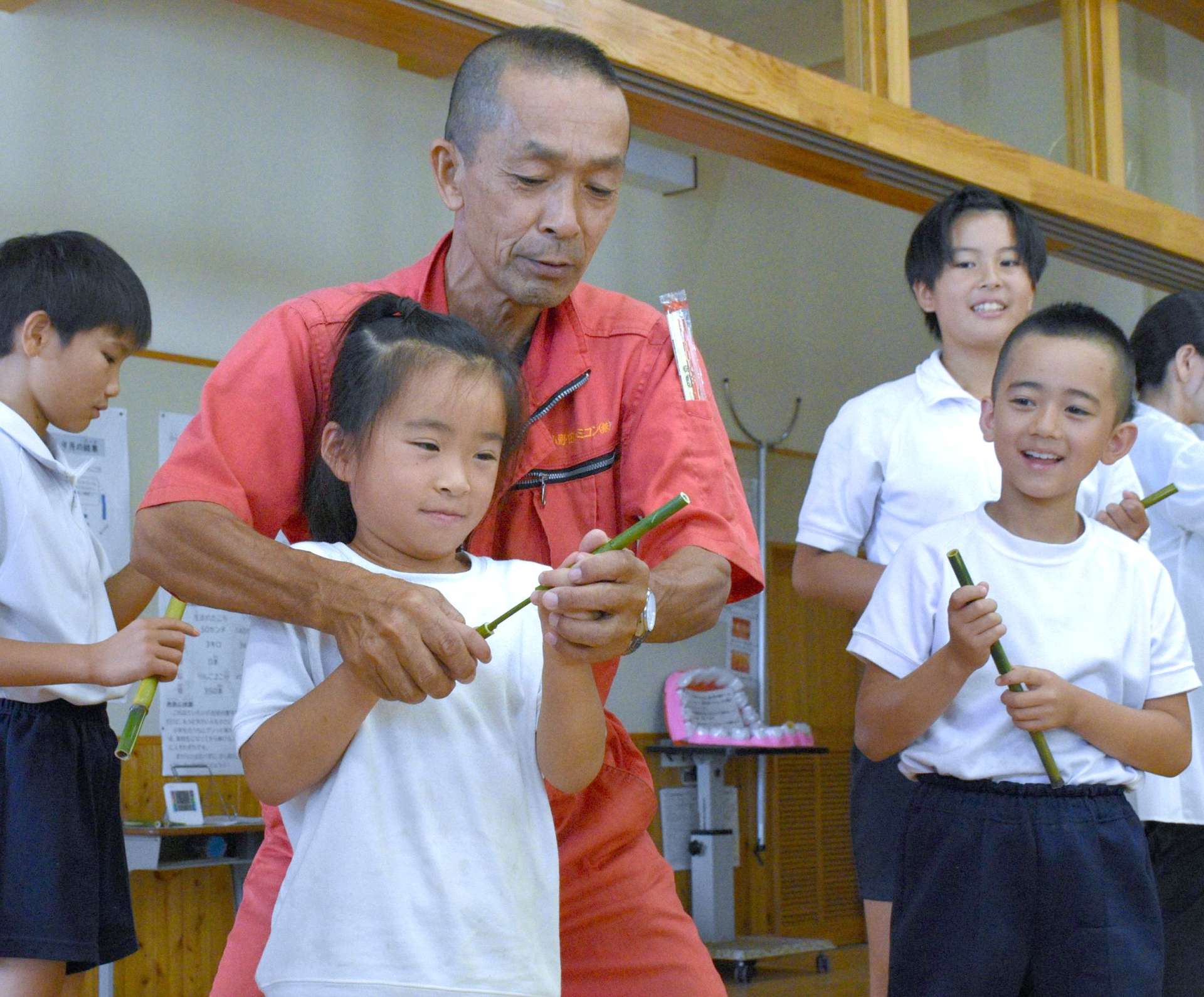 細い竹筒で作った突き鉄砲を試す児童ら＝西之表市の伊関小学校