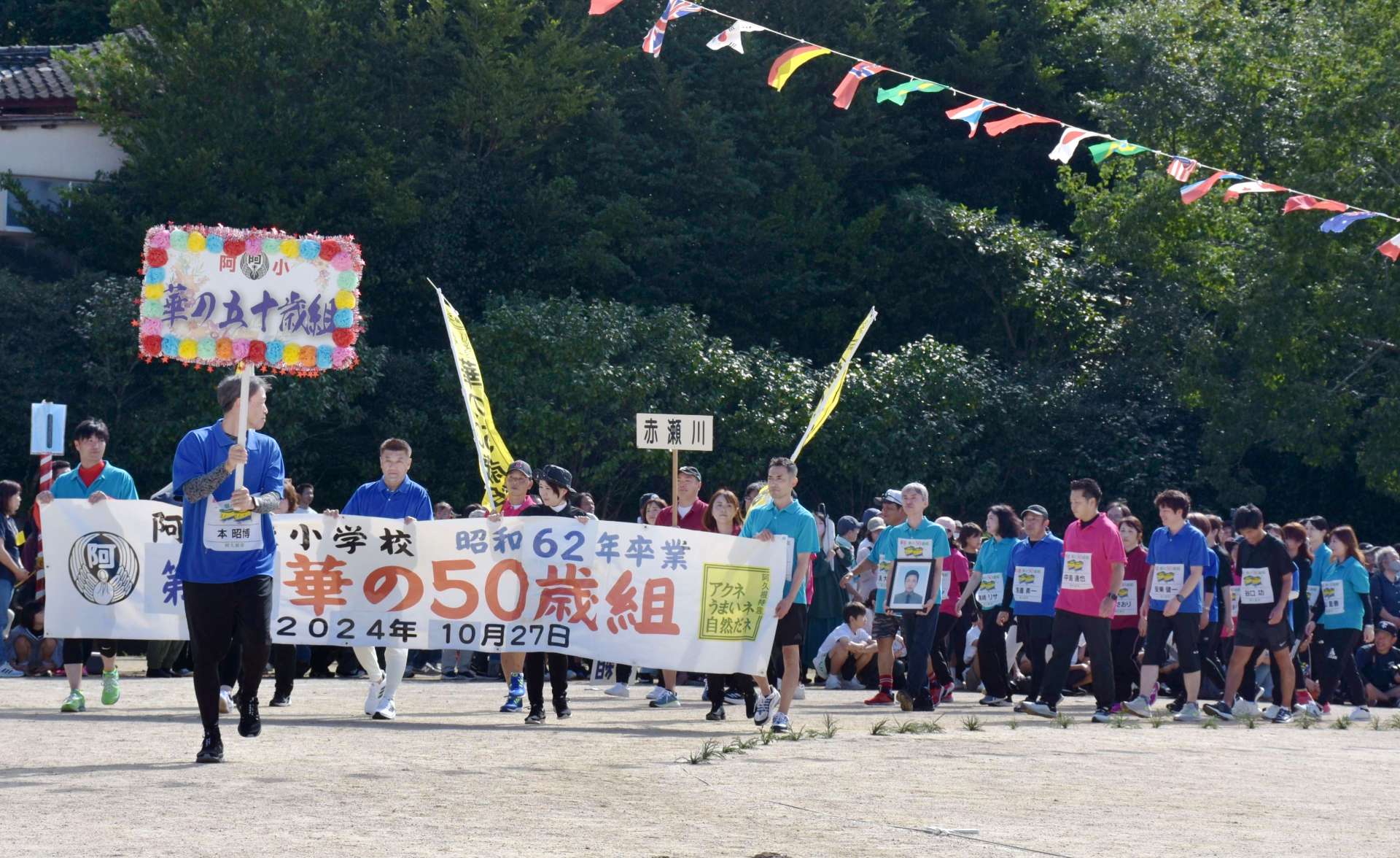 堂々と入場行進する「華の５０歳組」の卒業生ら＝２７日、阿久根市の阿久根小学校
