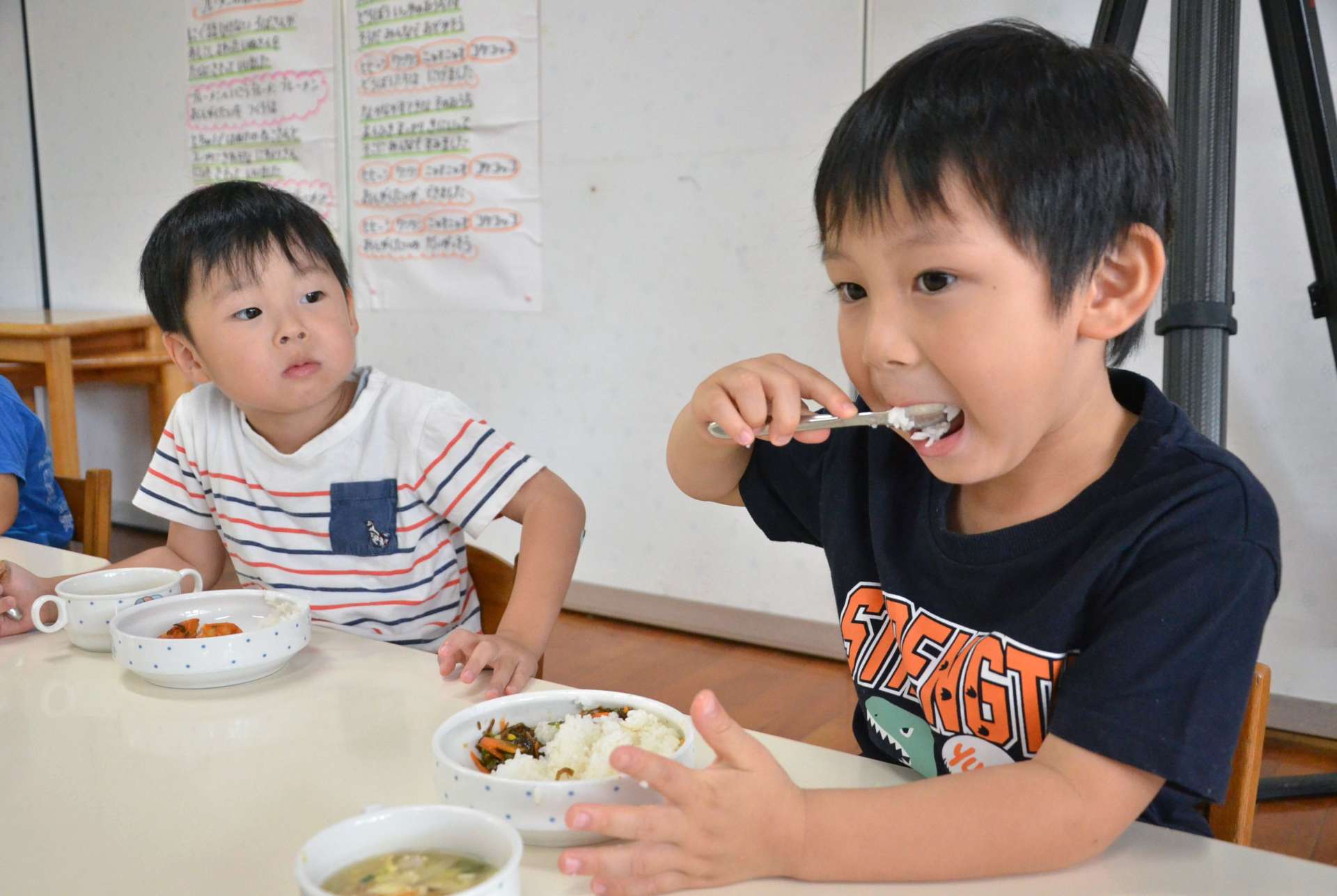 あきの舞の新米を頬張る園児＝３１日、さつま町中津川