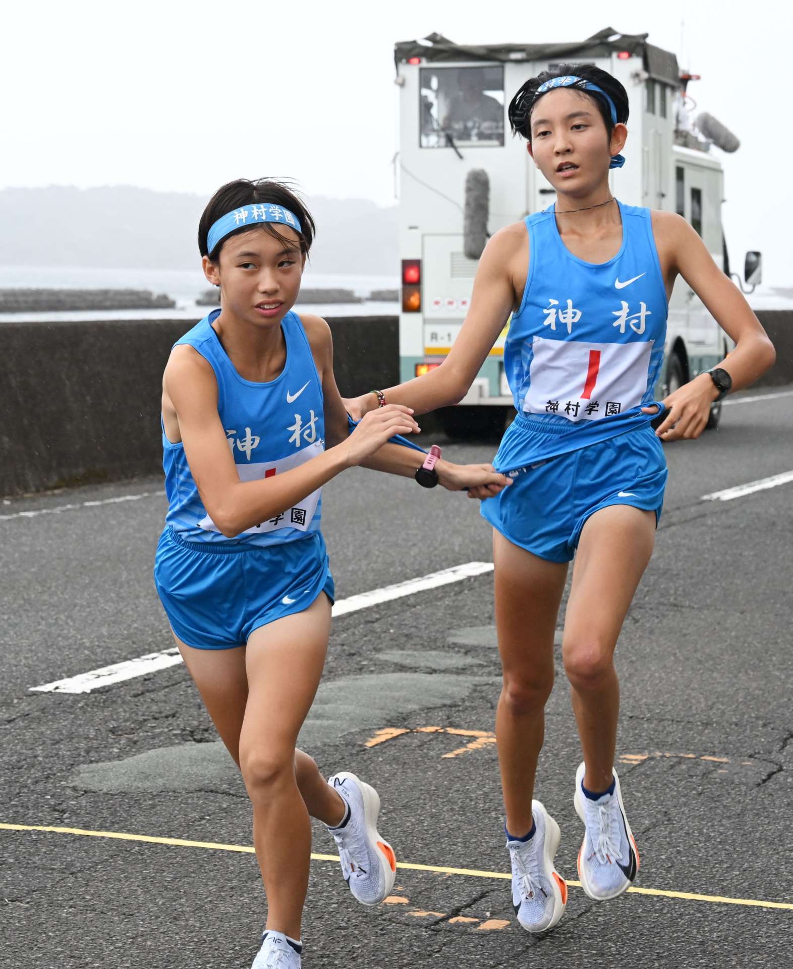第４中継所、神村の福元（右）から堂園にたすきリレー＝指宿市