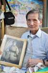 満州時代の写真を持つ緒方利光さん。体には今も手榴弾の破片１００個余りが残ったままだ＝伊佐市菱刈花北