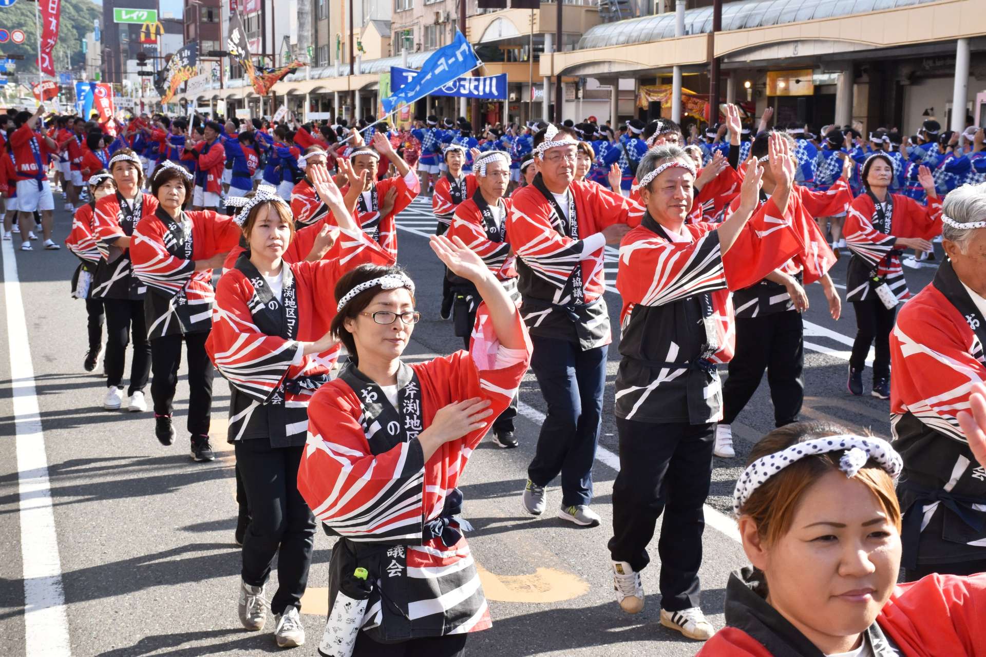 そろいの衣装で踊りを披露する参加者たち＝薩摩川内市
