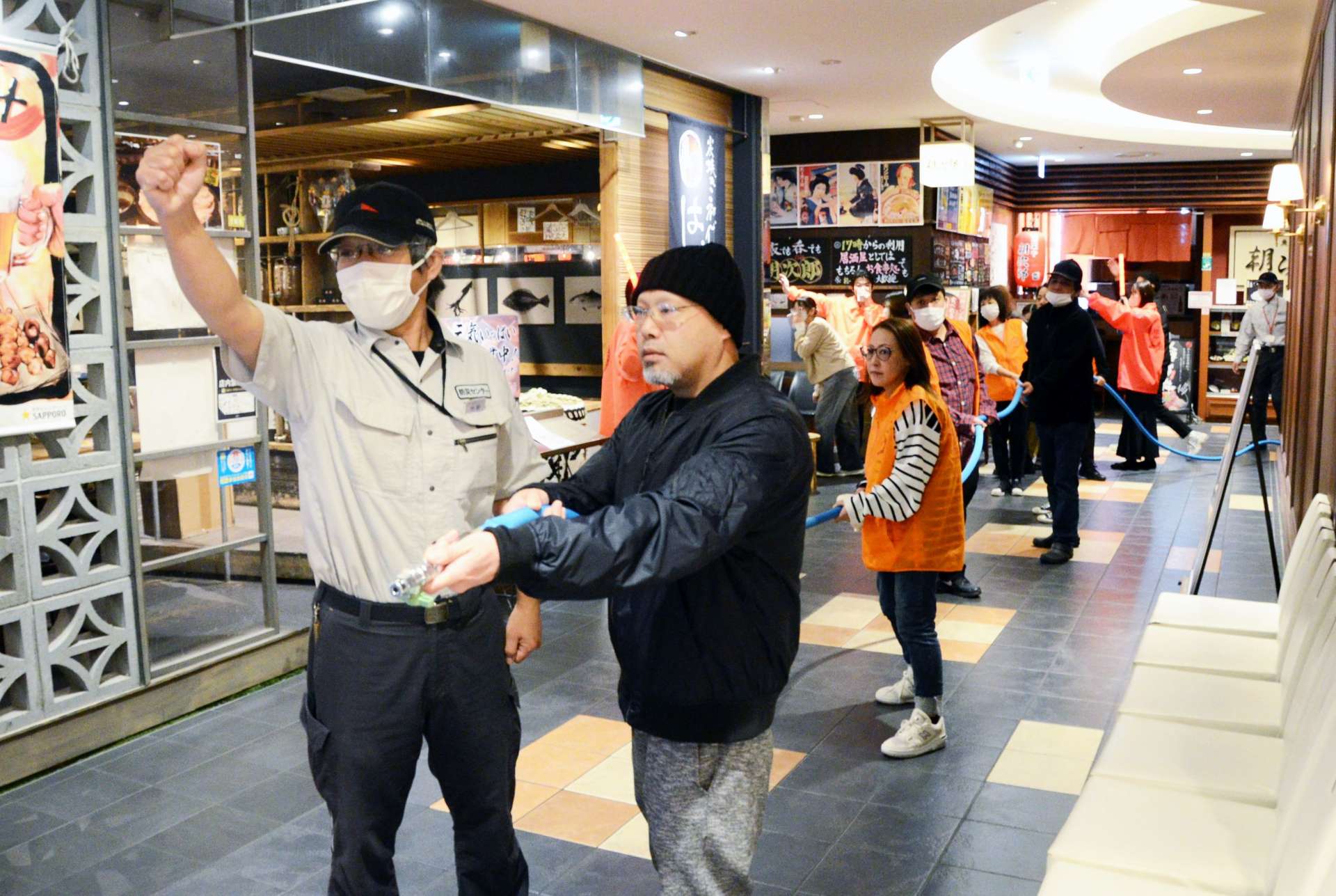 防災訓練で消火活動の手順を確認する従業員ら＝８日、鹿児島市のアミュプラザ鹿児島
