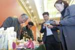 お菓子や芋焼酎などサツマイモの加工品をＰＲする日本からの参加者（左）＝８日、中国・河北省邯鄲市