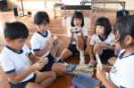 パッケージに入った宇宙食を手に取る児童＝西之表市の住吉小学校