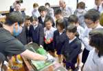 川内川あらしを再現する実験を見守る児童たち＝薩摩川内市の峰山小学校