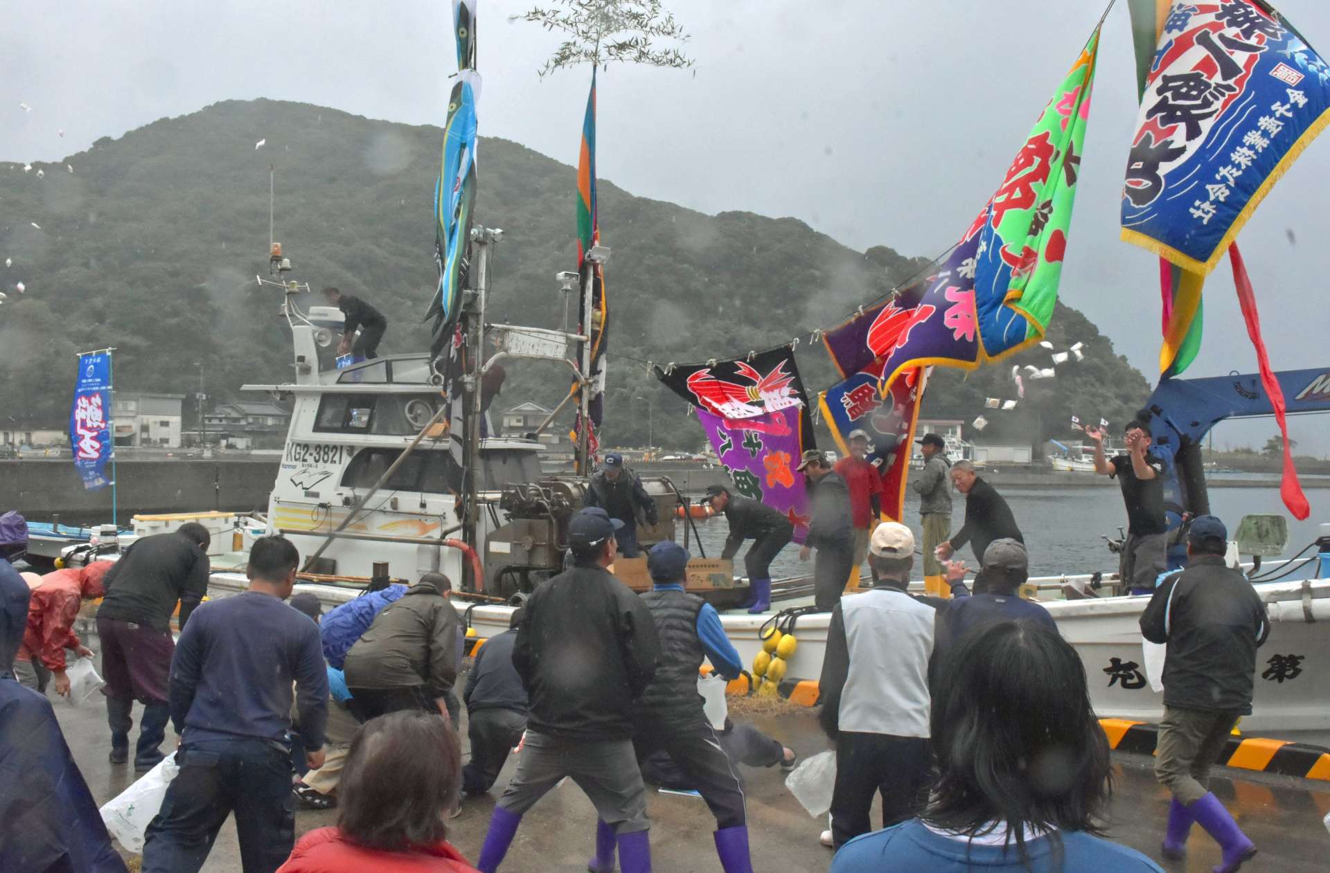 えびす祭りでもちまきを楽しむ住民ら＝長島町獅子島の幣串港