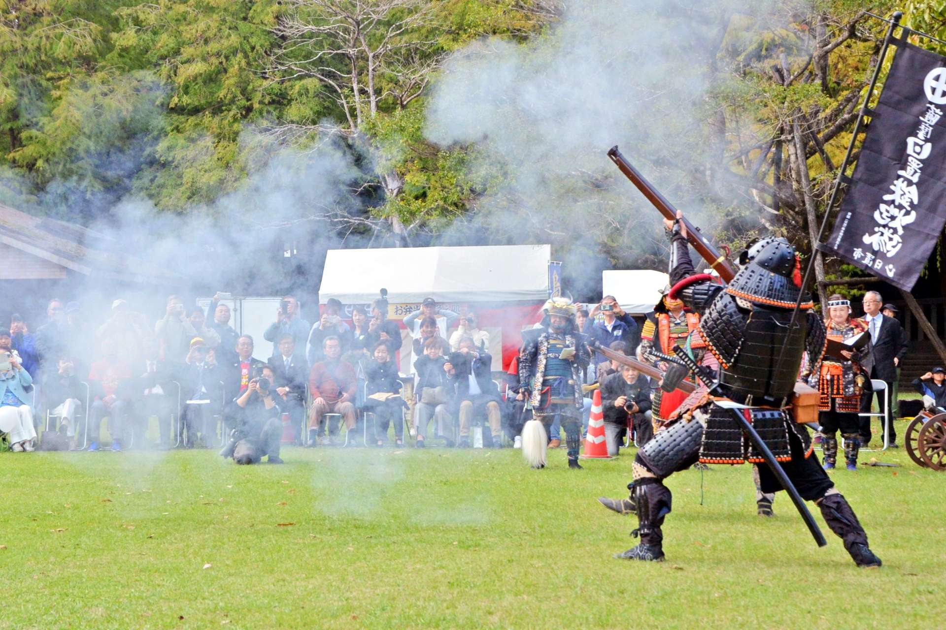 火縄銃のごう音に耳をふさぐ見物客＝都城市の神柱公園