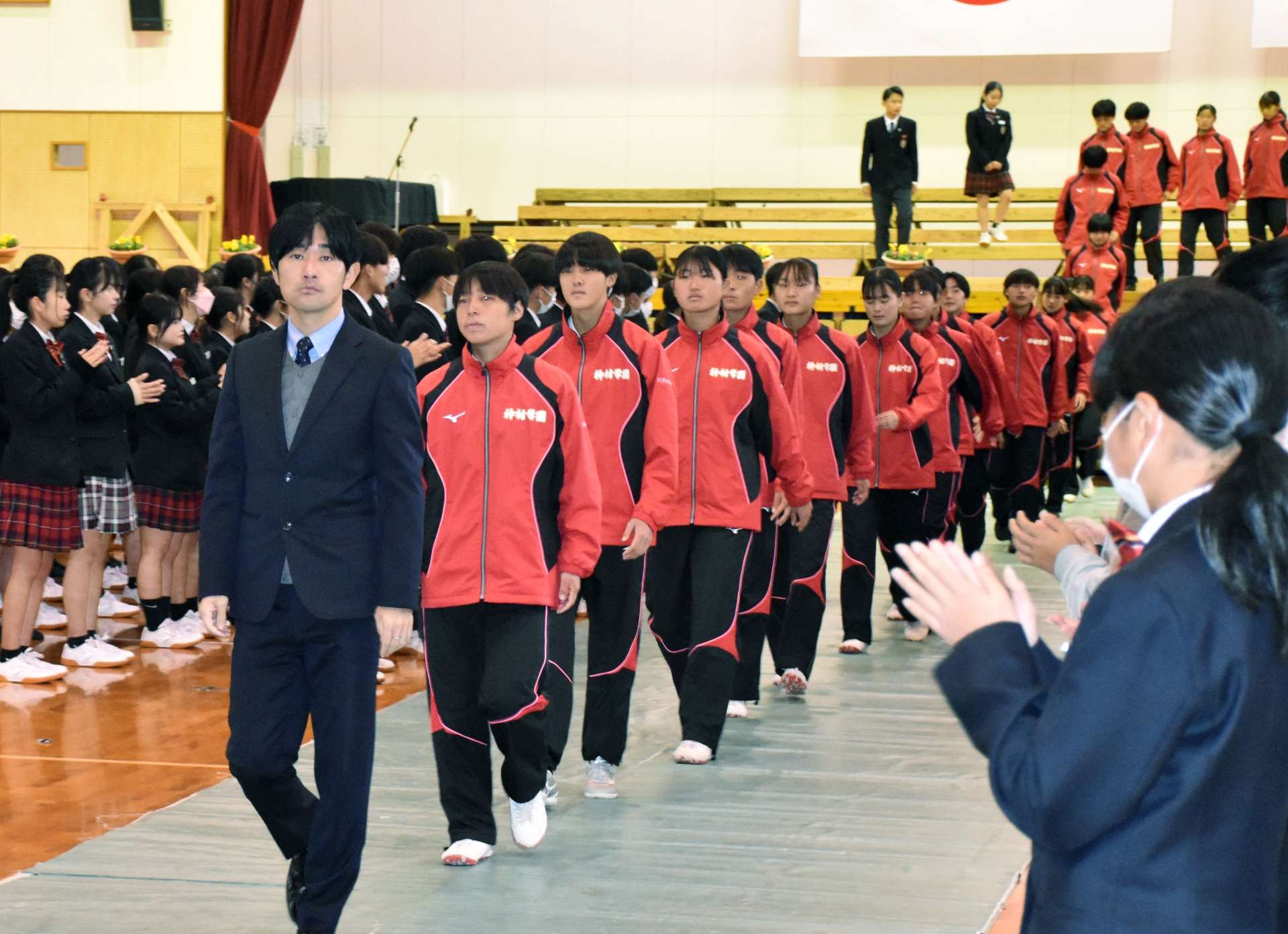 拍手で送り出される選手ら＝いちき串木野市の神村学園