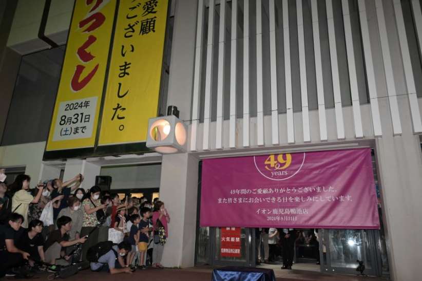 〈資料写真〉セレモニー後、閉店を伝える幕を見守る市民ら＝８月３１日、鹿児島市のイオン鹿児島鴨池店