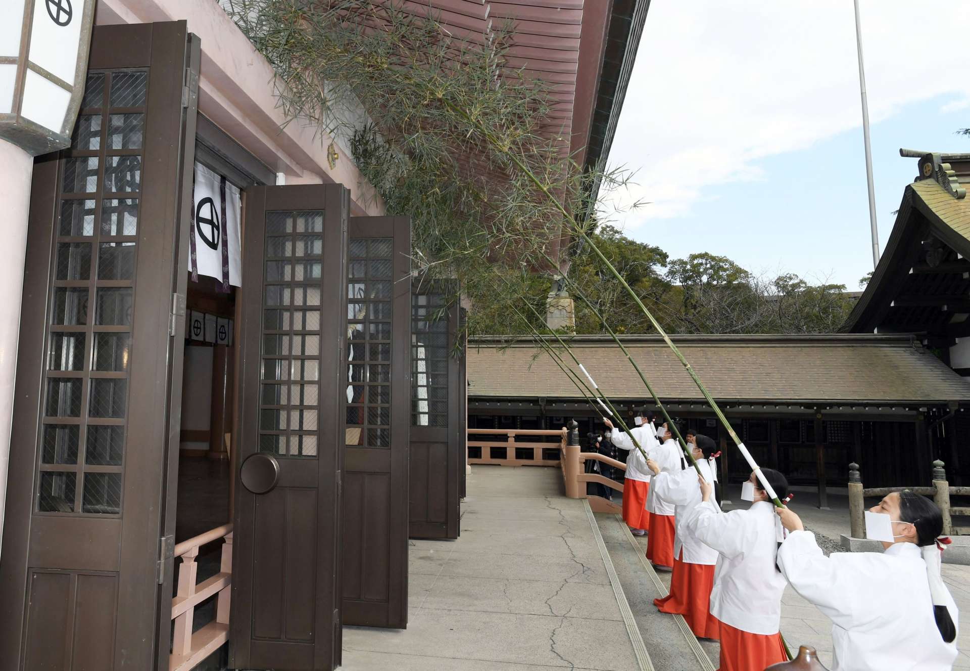 ササ竹で１年のほこりを払う巫女たち＝１３日、鹿児島市の照国神社