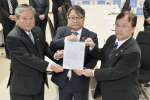 田中良二市長（右）らからの要望書を手にする九州電力の池辺和弘社長（中央）＝１８日、同市役所