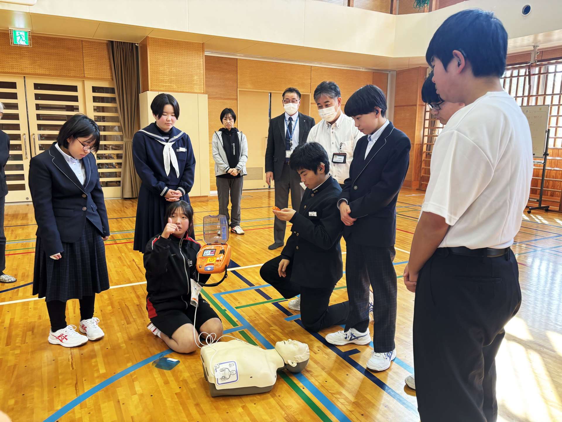 ＡＥＤの使い方を説明する生徒たち＝鹿児島市の鹿児島聾学校