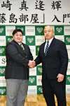 〈関連〉藤島親方（右）と握手を交わす樟南高の福崎真逢輝＝同校