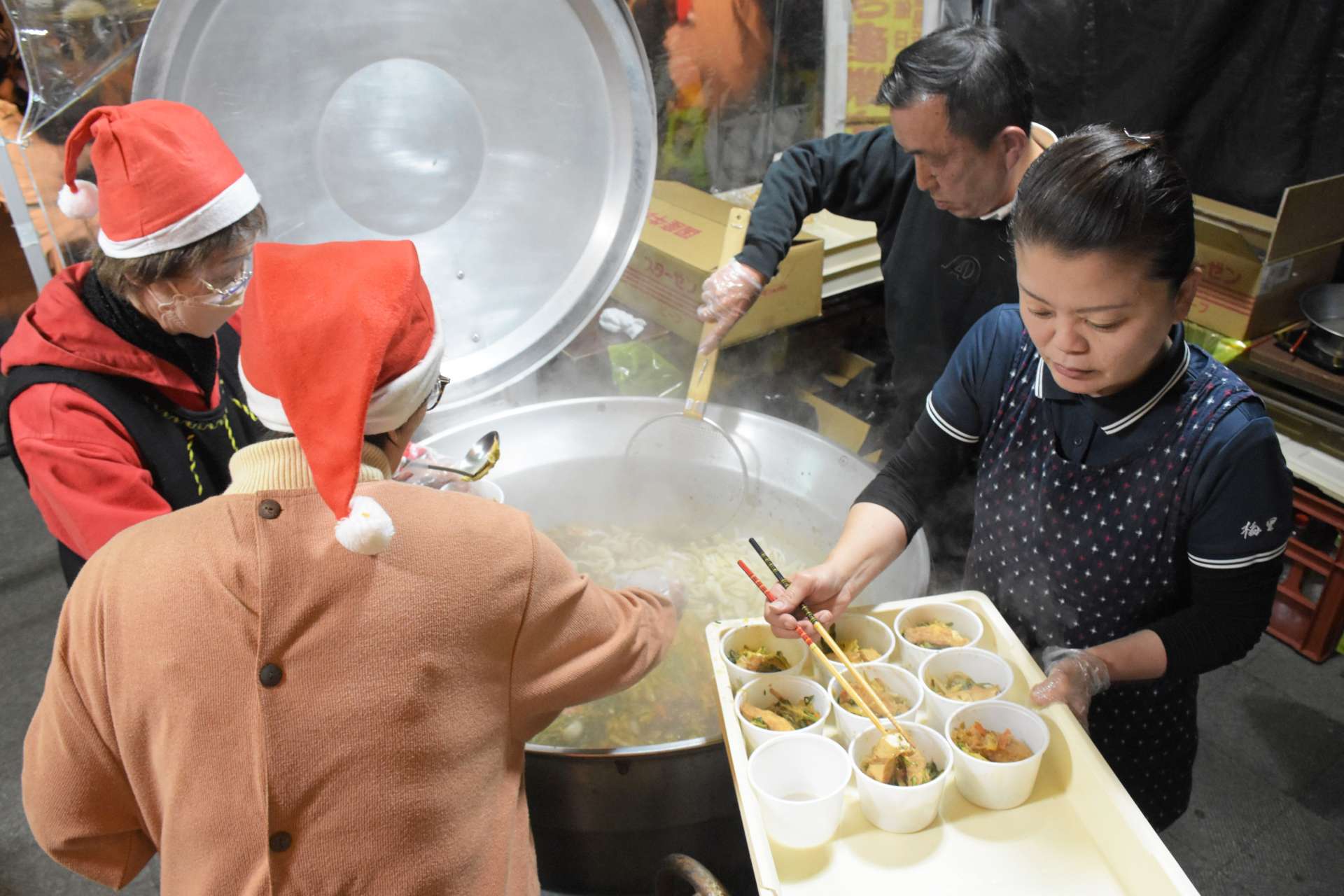 クリスマスイブに、指宿牛を使ったすき焼きを用意する店主ら＝２４日、指宿市のＪＲ指宿駅前