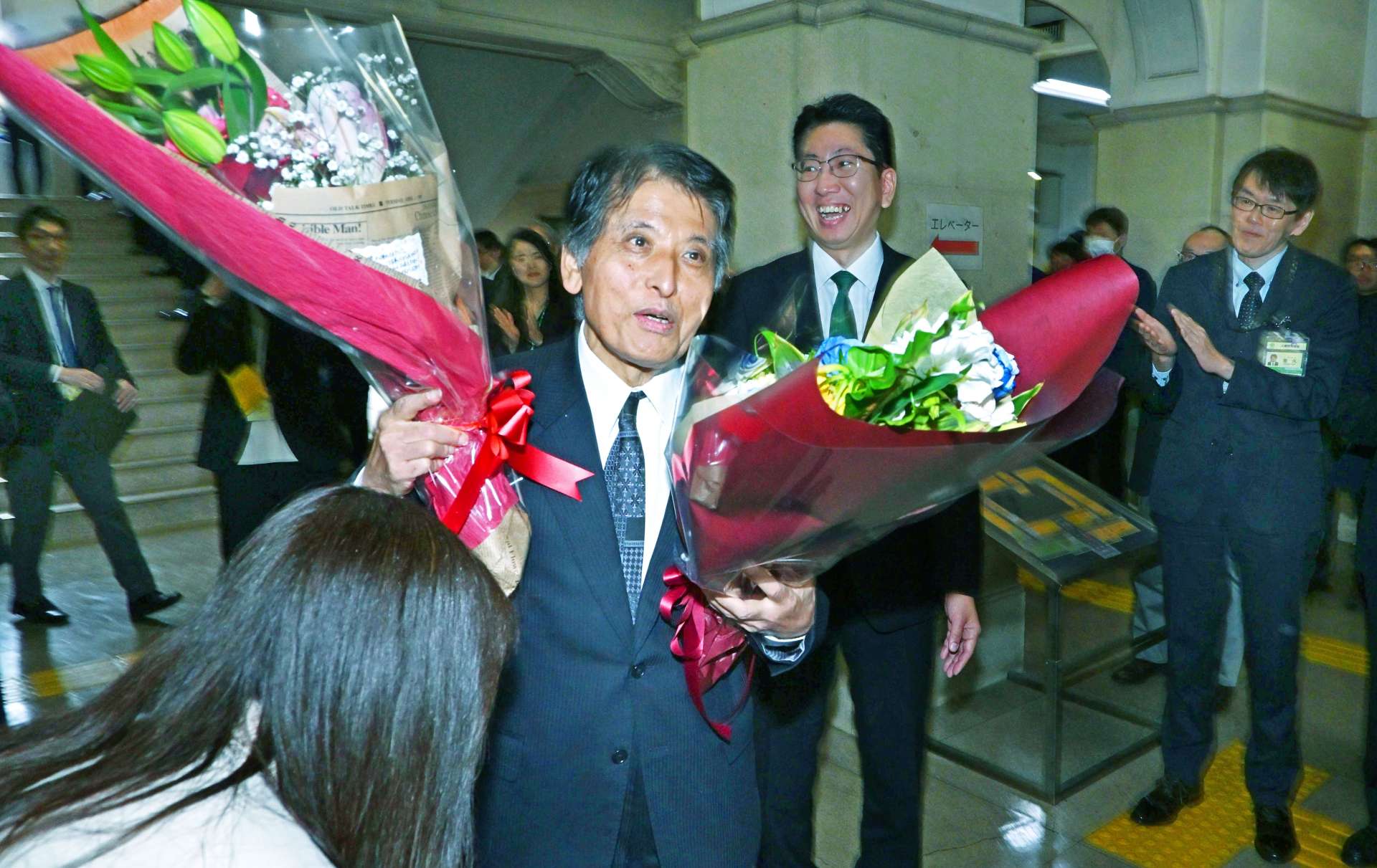 職員らに見送られ退庁する鹿児島市の松山芳英副市長＝２７日、同市役所