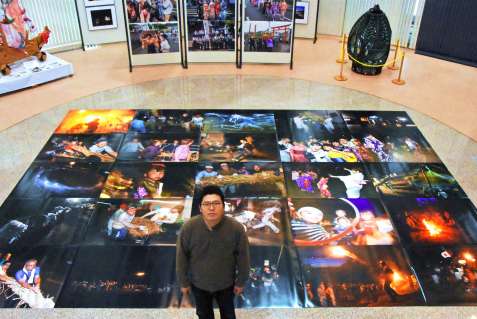 〈別カット〉坊津に１８年間通い撮影した写真を並べる山野雄樹さん＝南さつま市の輝津館