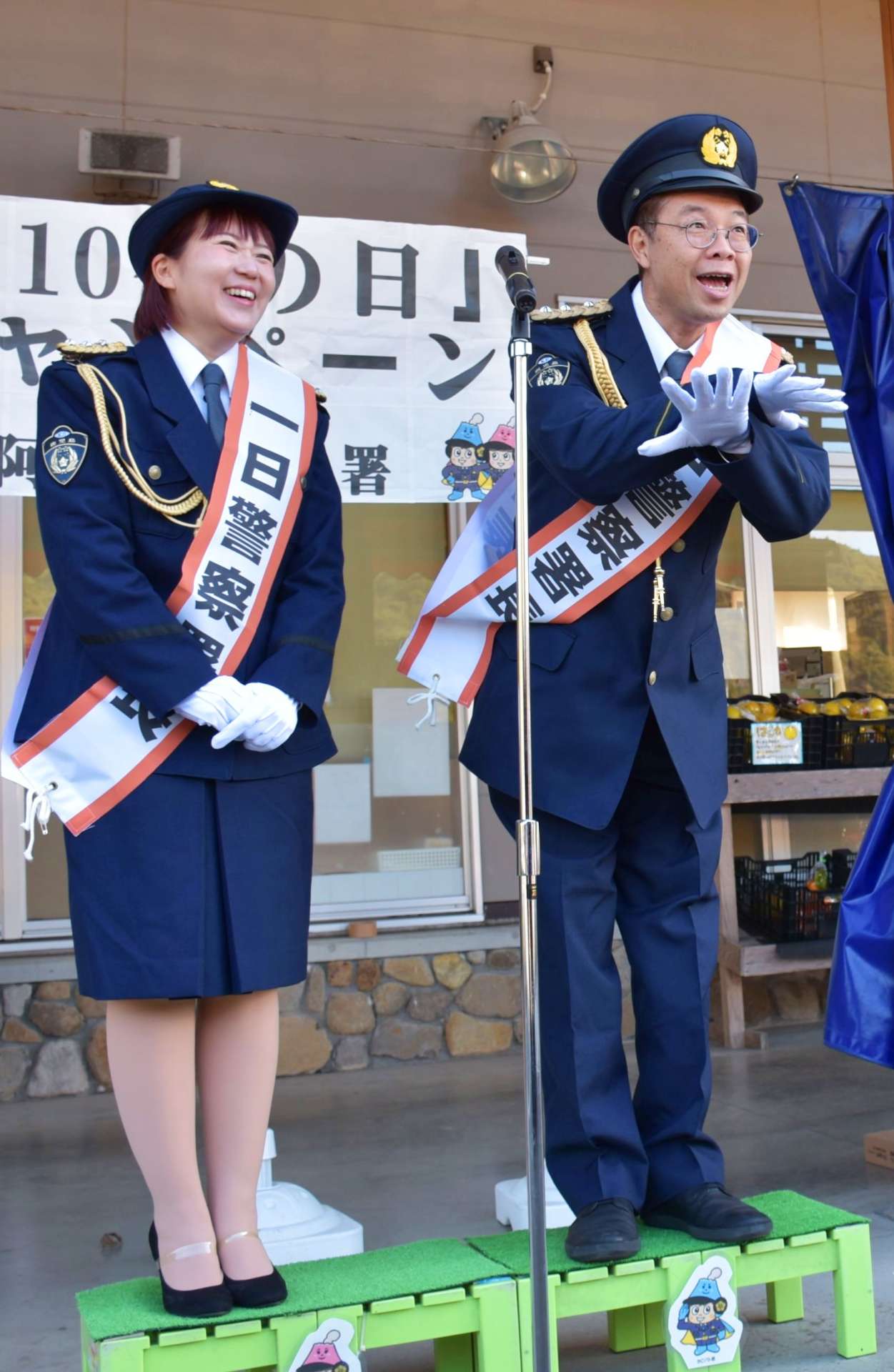 一日署長に任命され、おなじみのポーズをとる乾き亭げそ太郎さん（右）と久木崎みなみさん夫妻＝長島町の道の駅「黒之瀬戸だんだん市場」