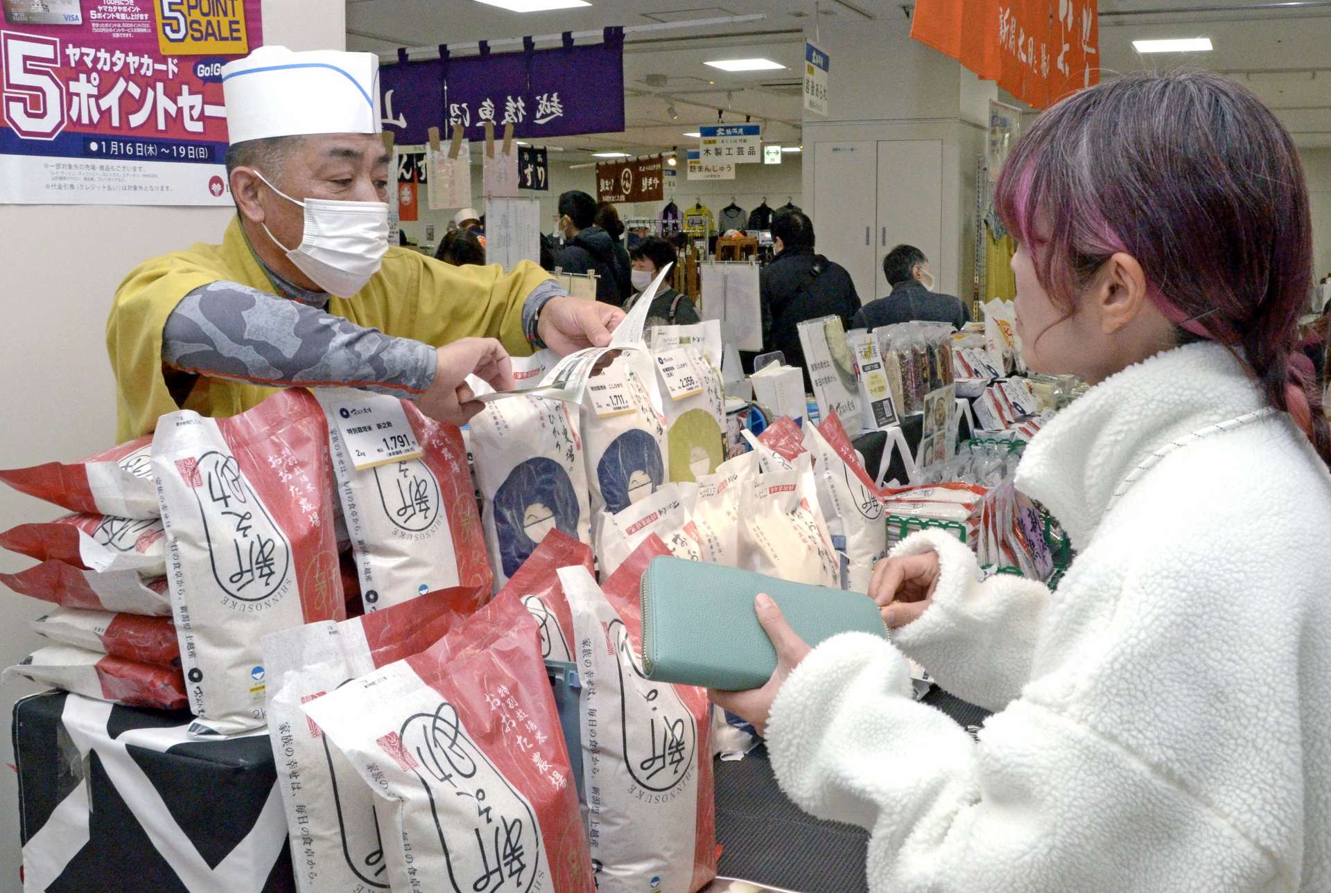 米どころ新潟の特産米を吟味する来場客＝１５日、鹿児島市の山形屋