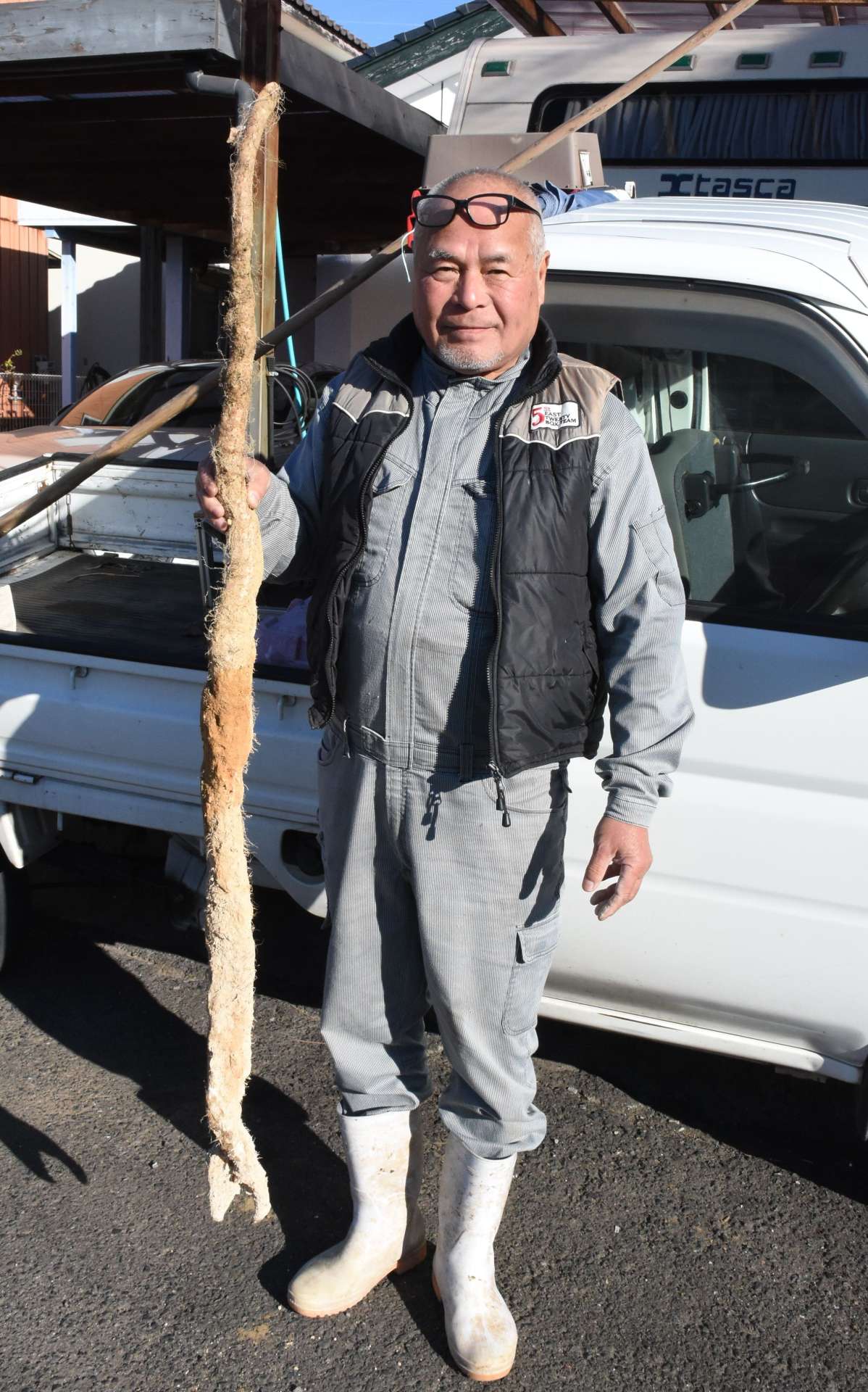収穫したジネンジョを持つ宇都哲さん＝霧島市国分中央５丁目