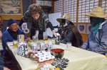 （左から）福満泉さん、トシエさん夫妻と価格交渉に臨む福の神ら＝１４日、都城市山田町山田