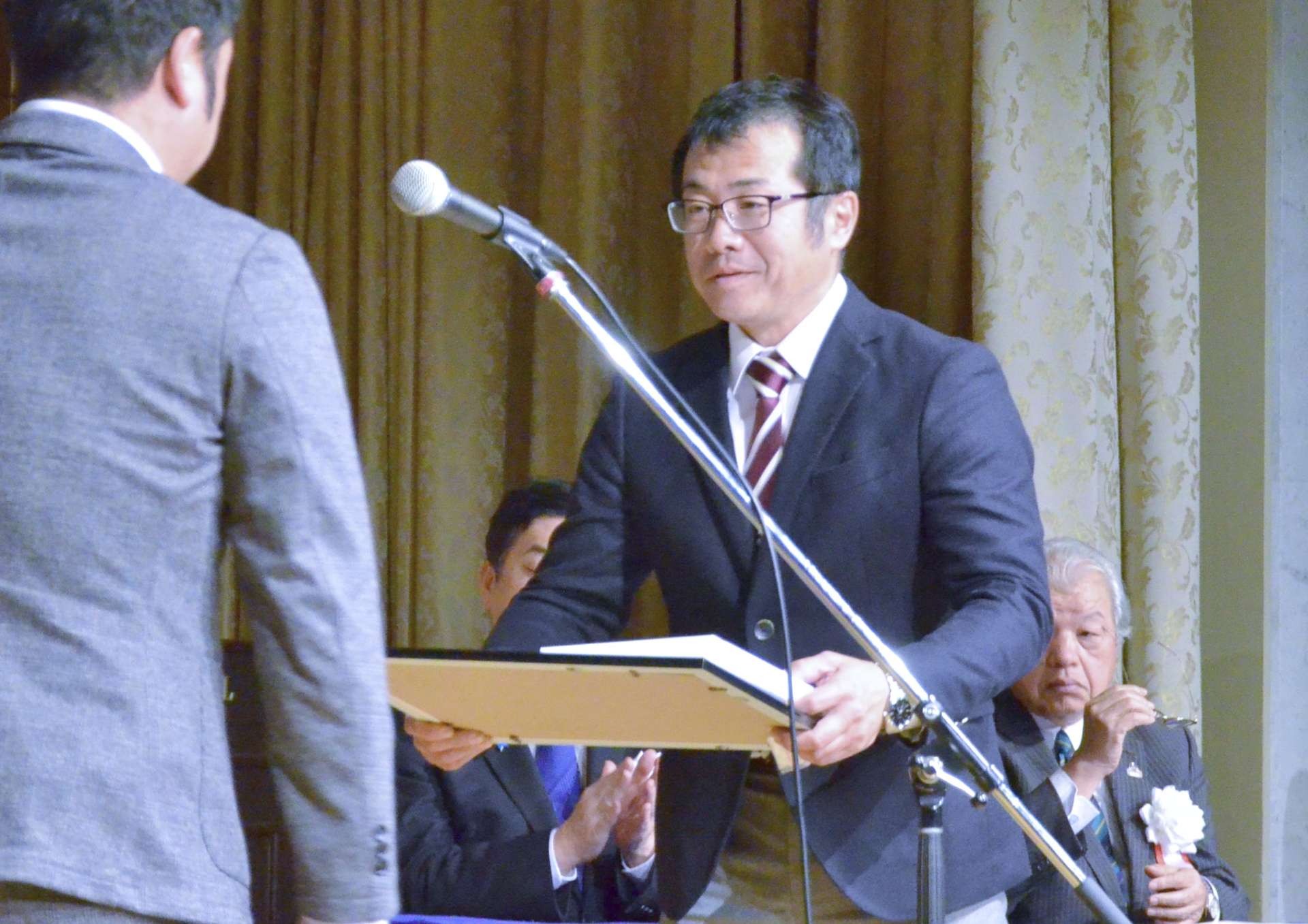功労者として表彰を受ける上室和久さん＝２４日、鹿児島市の城山ホテル鹿児島