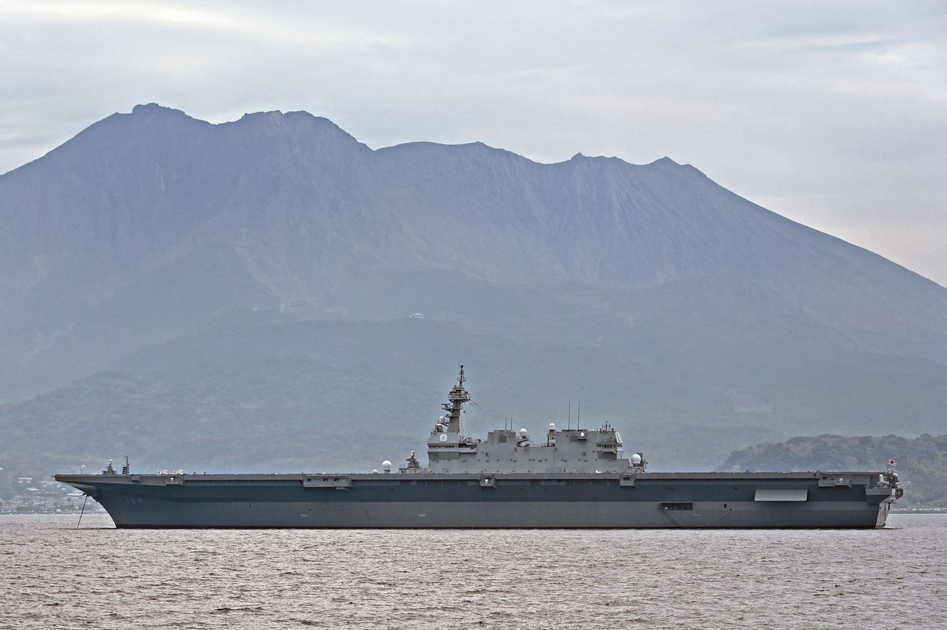 桜島を背に停泊する海上自衛隊の護衛艦「かが」＝２４日午前、鹿児島市祇園之洲町