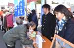 市川健一さんらと共に署名を呼びかける高校生＝２６日、鹿屋市串良