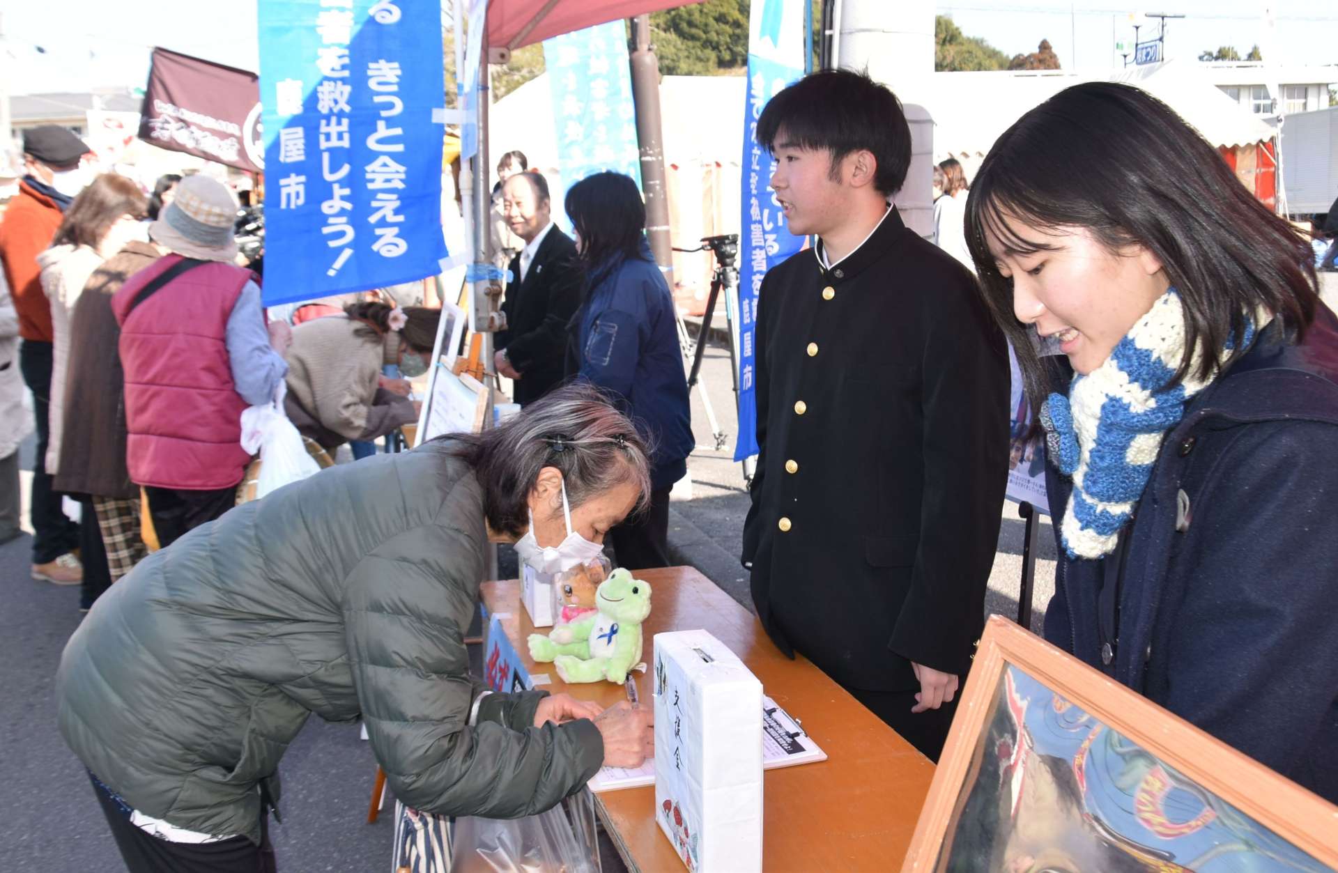 市川健一さんらと共に署名を呼びかける高校生＝２６日、鹿屋市串良