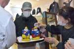 えびすと大黒の神像２体に焼酎を注ぎかける商店主ら＝阿久根市琴平町