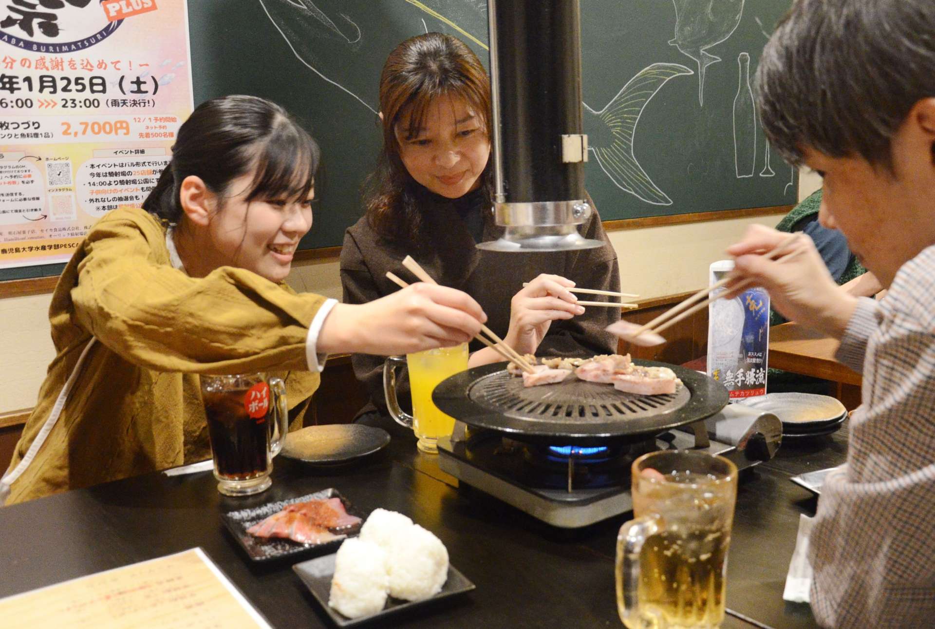 「騎射場ぶり祭」でブリ料理を楽しむ参加者＝２５日、鹿児島市荒田２丁目の焼きぶりあぶり
